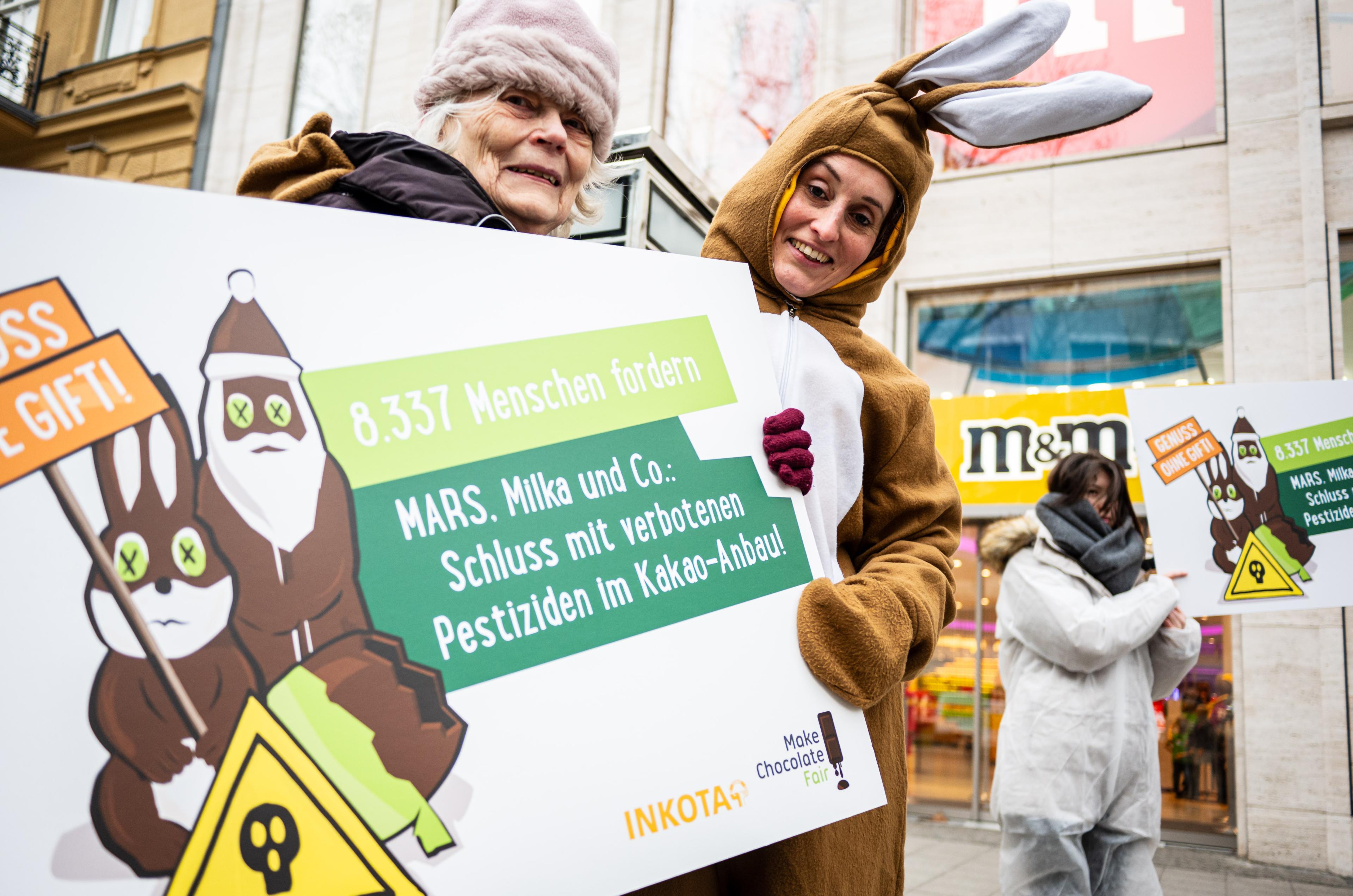 Das INKOTA-Team mit Unterstützerin aus dem Weltladen bei der Kundgebung und Protestaktion vor dem Mars M&M Store in Berlin zum Abschluss der "Genuss ohne Gift"-Aktion